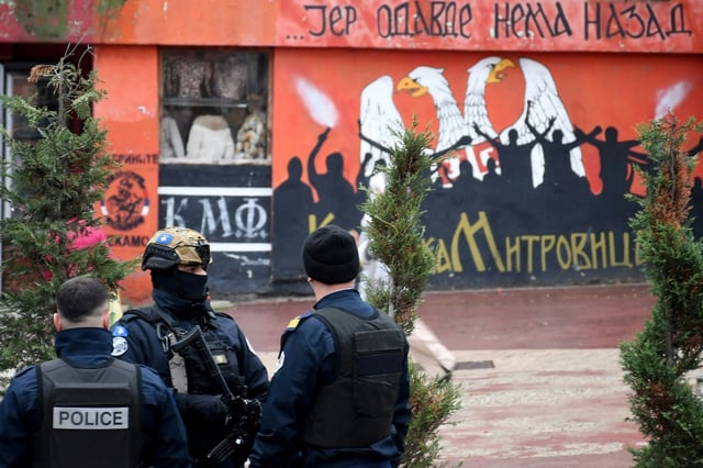 Kosovo police patrol next to a Serb mural in the ethnically divided northern city of Mitrovica