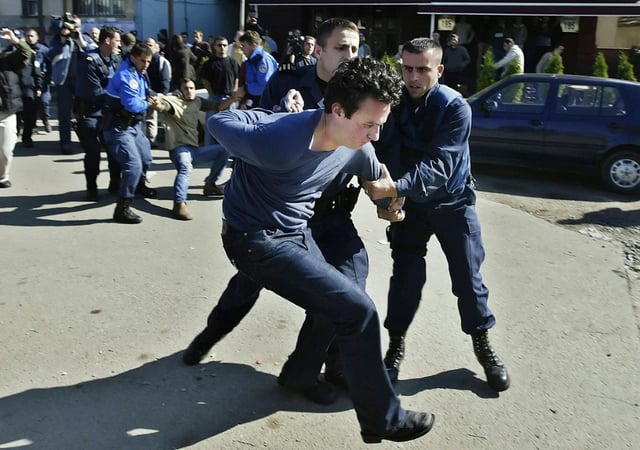 Kosovo police arrest a young Albin Kurti during a street protest in 2005