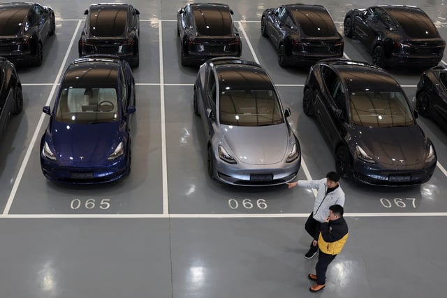 People walk past Tesla electric vehicles (EV) at the carmaker's delivery centre in Beijing, China January 8, 2025. REUTERS/Florence Lo/File photo