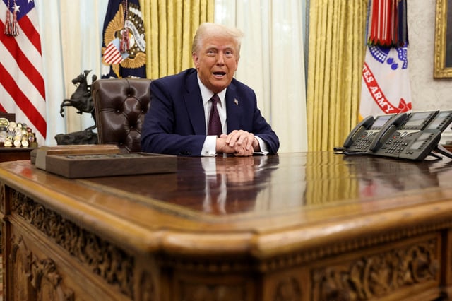 U.S. President Donald Trump sits in the Oval Office of the White House, as he signs executive orders, in Washington, U.S., January 23, 2025.   REUTERS/Kevin Lamarque/File Photo