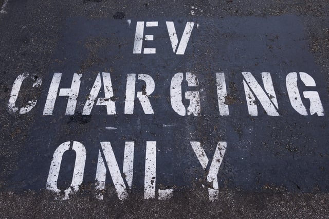 A parking space is marked specifically for an electric vehicle to charge charger in a shopping center parking lot in Oceanside, California, U.S.,October 19, 2023. REUTERS/Mike Blake/File Photo