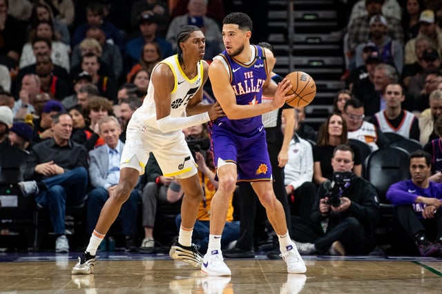 Devin Booker #1 of the Phoenix Suns controls the ball against Cody Williams #5 of the Utah Jazz during the second half of the NBA game at Footprint Center on January 11, 2025 in Phoenix, Arizona.