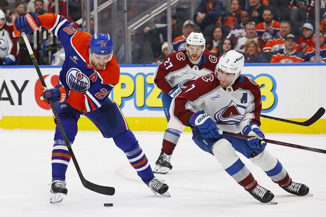 Feb 7, 2025; Edmonton, Alberta, CAN; Edmonton Oilers forward Leon Draisaitl (29) and Colorado Avalanche defensemen Devon Toews (7) battle for a loose puck during the third period at Rogers Place. Mandatory Credit: Perry Nelson-Imagn Images