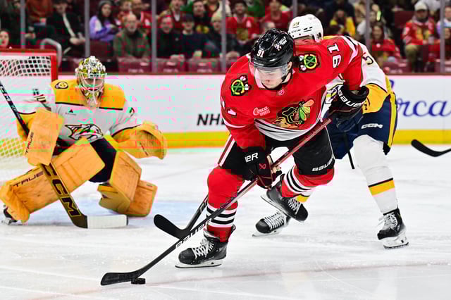 Feb 7, 2025; Chicago, Illinois, USA; Chicago Blackhawks center Frank Nazar (91) plays the puck against the Nashville Predators during the third period at the United Center. Mandatory Credit: Daniel Bartel-Imagn Images