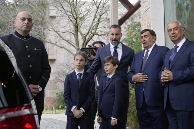 Prince Rahim Al-Hussaini, who was named Wednesday as the new Aga Khan, watches with his children the coffin being placed in a hearse during the funeral of Prince Karim Al-Hussaini, the Aga Khan IV, at the Ismaili Muslim community center in Lisbon, Saturday, Feb. 8, 2025. (AP Photo/Ana Brigida)