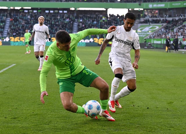 Soccer Football - Bundesliga - VfL Wolfsburg v Bayer Leverkusen - Volkswagen Arena, Wolfsburg, Germany - February 8, 2025 VfL Wolfsburg's Joakim Maehle in action with Bayer Leverkusen's Arthur REUTERS/Carmen Jaspersen