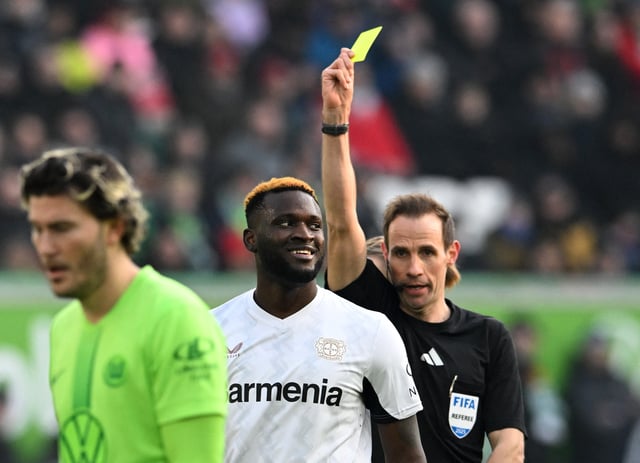 Soccer Football - Bundesliga - VfL Wolfsburg v Bayer Leverkusen - Volkswagen Arena, Wolfsburg, Germany - February 8, 2025 Bayer Leverkusen's Victor Boniface is shown a yellow card by referee Sascha Stegemann REUTERS/Carmen Jaspersen