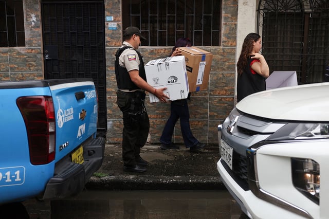 Police and officials of the National Electoral Council take a ballot box to homes for elderly and people with disabilities in Guayaquil, Ecuador, on Saturday, ahead of Sunday's presidential election.