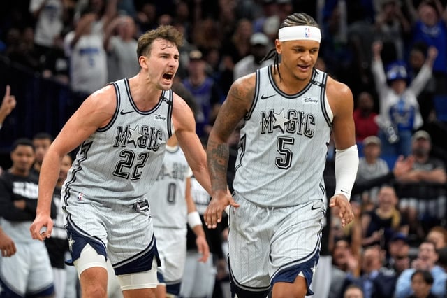 Magic forward Franz Wagner (22) celebrates after forward Paolo Banchero (5) made the game-winning shot in the closing moments on Saturday night.  (AP Photo/John Raoux)