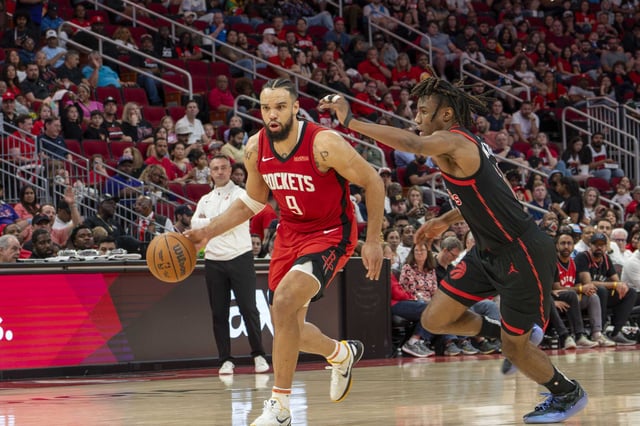 Houston Rockets forward Dillon Brooks (9) dribbles the ball past Toronto Raptors guard Ja&#39;Kobe Walter (14) in the second half of an NBA basketball game Sunday, Feb. 9, 2025 at the Toyota Center in Houston.