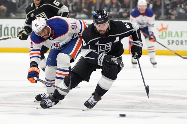 Los Angeles Kings defenseman Drew Doughty, right, takes the puck as Edmonton Oilers left wing Evander Kane reaches in during the first period in Game 4 of an NHL hockey Stanley Cup first-round playoff series Sunday, April 28, 2024, in Los Angeles. (AP Photo/Mark J. Terrill)