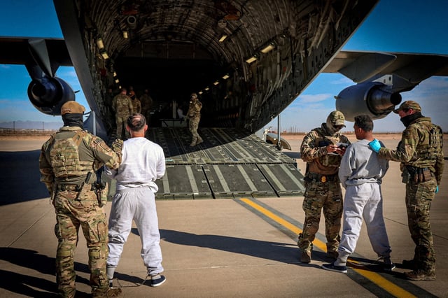 The first U.S. military aircraft to carry detained migrants to a detention facility at Guantanamo Bay, who U.S. Department of Homeland Security spokesperson Tricia McLaughlin called "highly dangerous criminal aliens", is boarded from an unspecified location in the U.S. February 4, 2025  DHS/Handout via REUTERS/File Photo