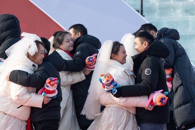 Couples hug each other during a group wedding at the Harbin Ice-Snow World in Harbin, northeast China's Heilongjiang Province on January 6, 2025.