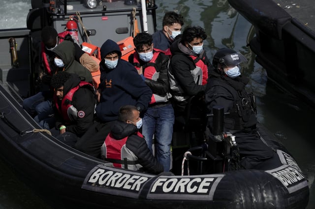 FILE - People thought to be migrants who undertook the crossing from France in small boats and were picked up in the Channel, arrive to be disembarked from a small transfer boat which ferried them from a larger British border force vessel that didn't come into the port, in Dover, south east England, Friday, June 17, 2022. (AP Photo/Matt Dunham, File)