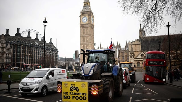 Farmers drive their tractor in front of the Elizabeth Tower, commonly known by the name of the clock's bell Big Ben, at the Palace of Westminster, home to the Houses of Parliament, during a farmer demonstration to protest against changes to inheritance tax rules for land ownership for farmers, in central London, on February 10, 2025. (Photo by HENRY NICHOLLS / AFP)