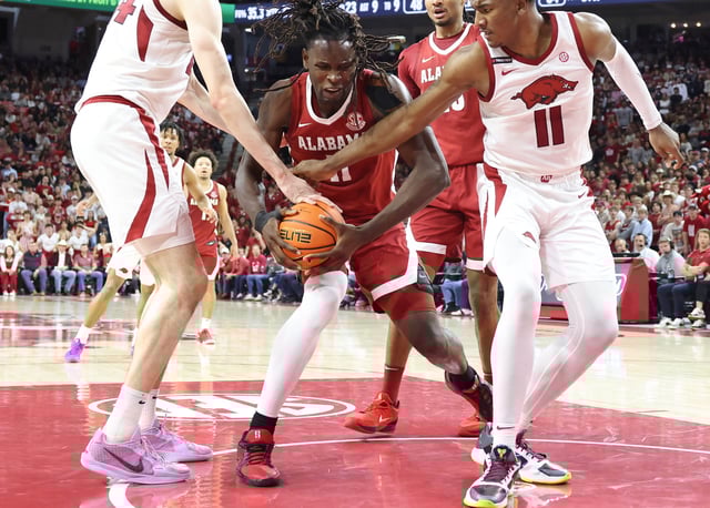 Alabama center Clifford Omoruyi (11) controls the ball as Arkansas forwards Zvonimir Ivisic (44) and Karter Knox (11) defend during the second half at Bud Walton Arena.