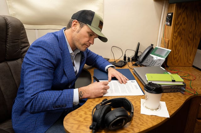 Secretary of Defense Pete Hegseth signs a memorandum reversing the name of Fort Liberty back to Fort Bragg while flying in a C-17 operated by the 300th Airlift Squadron en route to Stuttgart, Germany, Feb. 10, 2025.