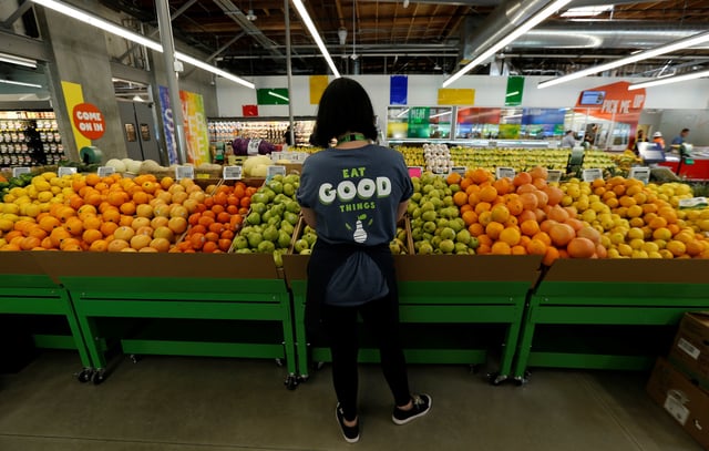 An employee checks pears at a 365 by Whole Foods Market grocery store ahead of its opening day in Los Angeles, U.S., May 24, 2016. REUTERS/Mario Anzuoni/File Photo