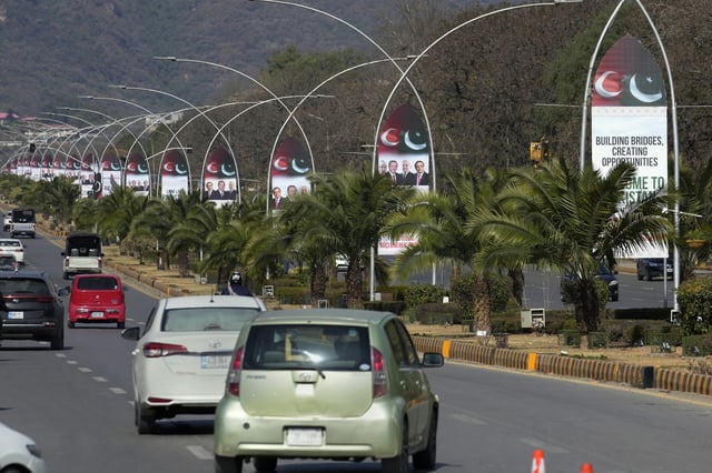Vehicles drive past welcoming billboards with the pictures of Turkish President Recep Tayyip Erdogan, Pakistan's President Asif Ali Zardari and Prime Minister Shehbaz Sharif display on a road in Islamabad, Pakistan, Wednesday, Feb. 12, 2025. (AP Photo/Anjum Naveed)