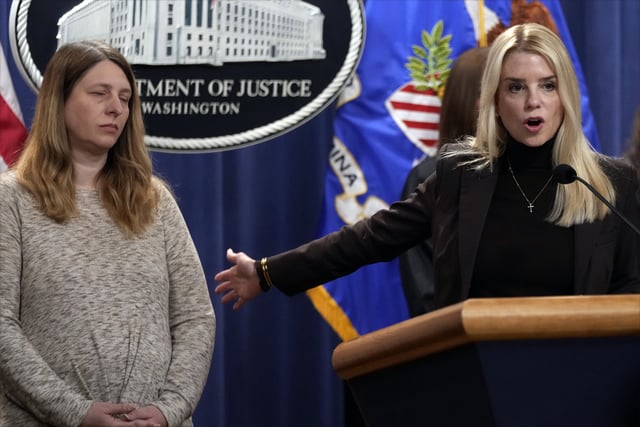 Attorney General Pam Bondi speaks at a news conference regarding immigration enforcement at the Justice Department, Wednesday, Feb. 12, 2025, in Washington, as Tammy Nobles, mother of Kayla Hamilton, listens. (AP Photo/Ben Curtis)