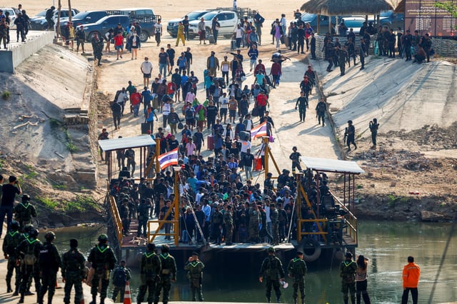 Multinational victims of scam centers, who were tricked or trafficked into working in Myanmar, walk towards a vessel in order to cross Moei River to Thailand, in Phop Phra District, Tak province, Thailand February 12, 2025. REUTERS/Krit Phromsakla Na Sakolnakorn