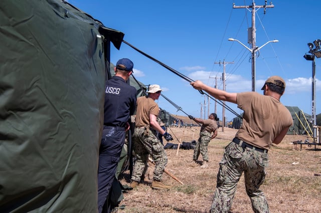 U.S. Navy sailors and Coast Guardsmen erect expeditionary shelter tents in support of the expansion of migrant detention at Naval Station Guantanamo Bay, Cuba, February 2, 2025.
