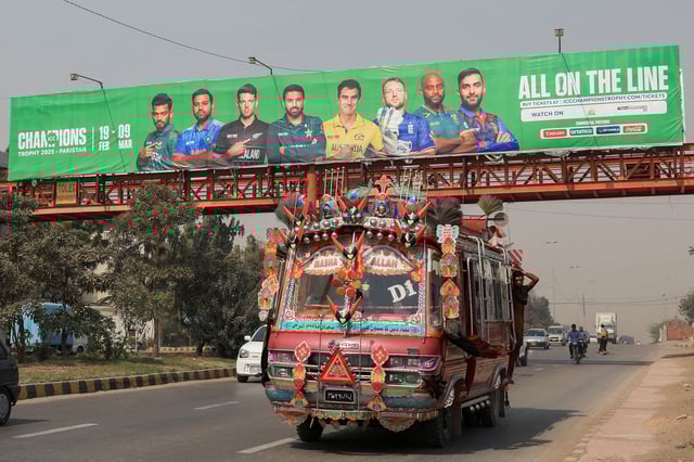 A decorated van drives past under a pedestrian bridge with an advertisment banner, ahead of the ICC Champions Trophy 2025 tournament, in Karachi, Pakistan February 13, 2025. REUTERS/Akhtar Soomro/File Photo