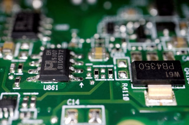 Semiconductor chips are seen on a printed circuit board in this illustration picture taken February 17, 2023. REUTERS/Florence Lo/Illustration/File Photo