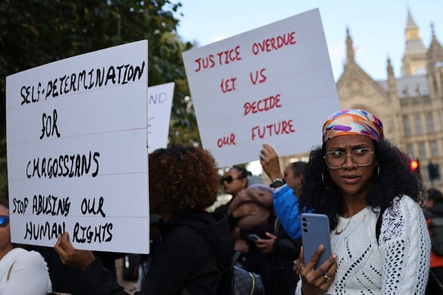Members of the Chagossian community gather with banners and placards outside Parliament to protest against the Government&#39;s decision (Photo: Adrian Dennis/AFP/Getty)