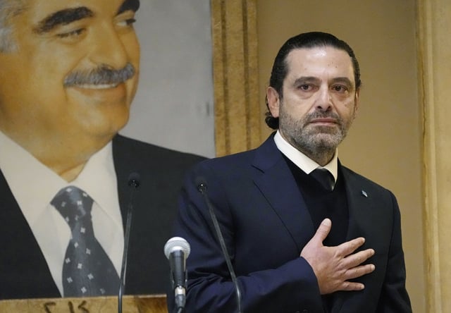FILE - Former Lebanese Prime Minister Saad Hariri, gestures in front of a picture of his late father and former Prime Minister of Lebanon Rafic Hariri at his house in downtown Beirut, Lebanon, on Jan. 24, 2022. (AP Photo/Hussein Malla, File)