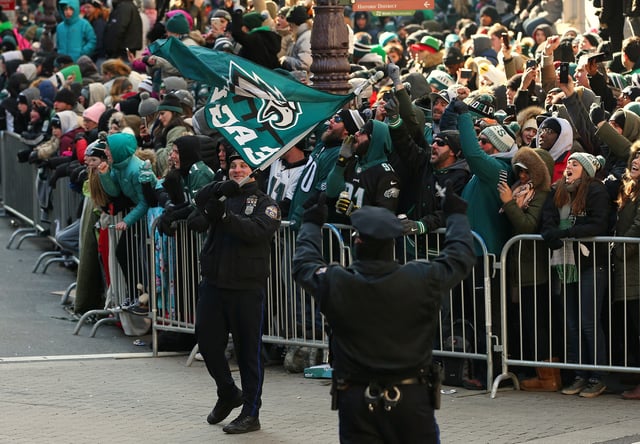 Two Philadelphia Police officers lead the crowd in a singing of &#34;Fly Eagles Fly&#34; during the Philadelphia Eagles Super Bowl Victory Parade on February 8, 2018 in Philadelphia, Pennsylvania.