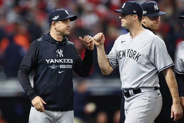 Manager Aaron Boone #17 of the New York Yankees fist bumps Clay Holmes #35 after defeating the Cleveland Guardians in game four of the American League Division Series at Progressive Field on October 16, 2022 in Cleveland, Ohio.