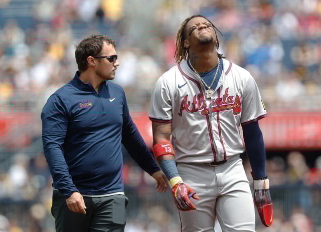 May 26, 2024; Pittsburgh, Pennsylvania, USA;  Atlanta Braves right fielder Ronald Acuña Jr. (13) reacts as he  leaves the field assisted by a Braves trainer after Acuña suffered an apparent injury on a steal attempt against the Pittsburgh Pirates during the first inning at PNC Park. Mandatory Credit: Charles LeClaire-USA TODAY Sports/File Photo