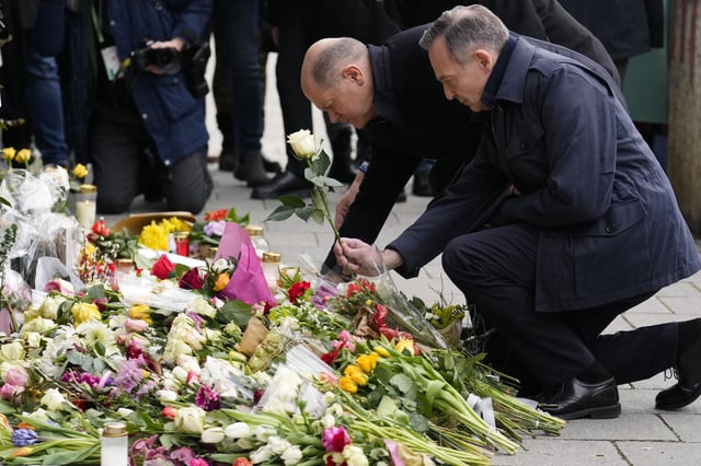 German Chancellor Olaf Scholz, left, and Volker Wissing, Minister of Justice and Federal Minister for Digital and Transport, lay down flowers at the site where a car crashed into a Ver.di demonstration two days before, in Munich, Saturday, Feb. 15, 2025. (AP Photo/Ebrahim Noroozi)