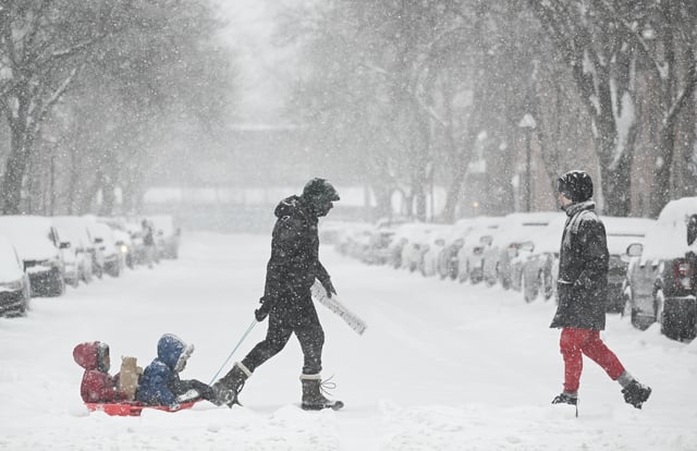 People cross a street during a snowstorm in Montreal, Thursday, Feb. 13, 2025. THE CANADIAN PRESS/Graham Hughes