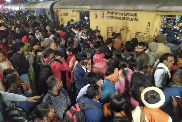Passengers jostle to board a train at the railway station in New Delhi, India, on Feb.15, 2025.