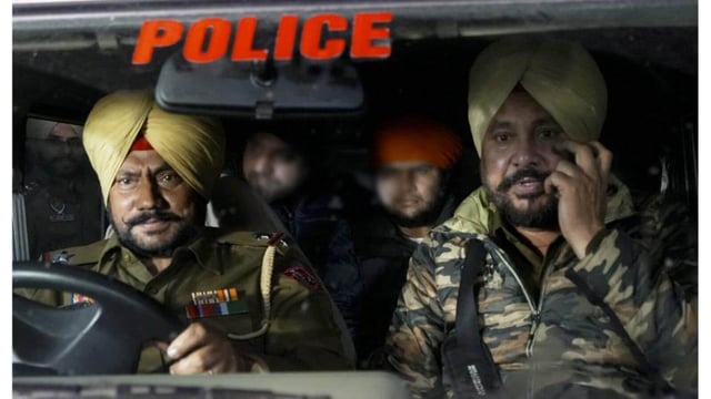 Indians deported from the US being escorted by the police as they leave the airport upon their arrival, in Amritsar, early Sunday. (PTI)