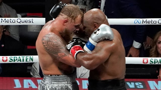 US YouTuber/boxer Jake Paul (L) and US retired pro-boxer Mike Tyson (R) hug at the end of their heavyweight boxing bout at The Pavilion at AT&T Stadium in Arlington, Texas, November 15, 2024. (Photo by TIMOTHY A. CLARY / AFP)