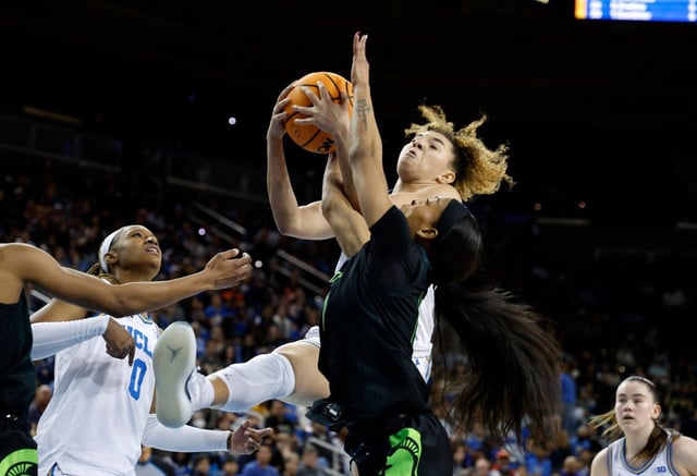 UCLA guard Kiki Rice pulls down a rebound against Michigan State guard Jocelyn Tate during the first half of an NCAA college basketball game, Sunday, Feb. 16, 2025, in Los Angeles. (AP Photo/Kevork Djansezian)