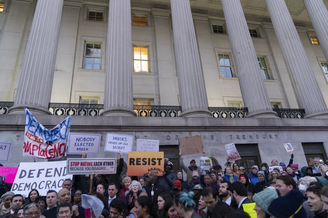 People listen to speakers during a rally against Elon Musk outside the Treasury Department in Washington, Tuesday, Feb. 4, 2025. (AP Photo/Jose Luis Magana)