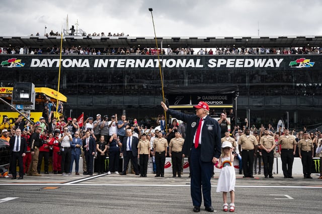 President Donald Trump, accompanied by his granddaughter Carolina Trump, greets attendees prior to riding in the Presidential limousine ahead of the start of the Daytona 500 Nascar race at Daytona International Speedway in Daytona Beach, Florida, on Sunday, February 16, 2025.