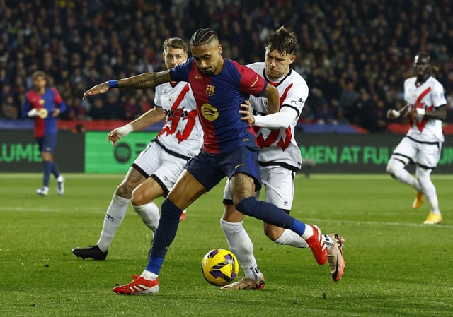 Soccer Football - LaLiga - FC Barcelona v Rayo Vallecano - Estadi Olimpic Lluis Companys, Barcelona, Spain - February 17, 2025 FC Barcelona's Raphinha in action with Rayo Vallecano's Andrei Ratiu REUTERS/Albert Gea