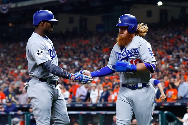 Justin Turner #10 of the Los Angeles Dodgers celebrates scoring on a RBI single during the first inning with Yasiel Puig #66 against the Houston Astros in game five of the 2017 World Series at Minute Maid Park on October 29, 2017 in Houston, Texas.