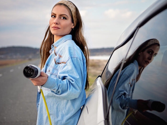 Desperate woman with electric car without power in battery is looking for help