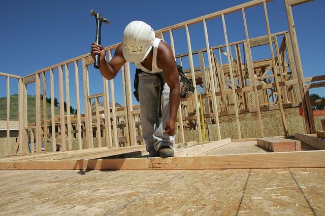 A construction worker hammers nails as he builds wall frames for a new home March 31, 2005 in Richmond, California.