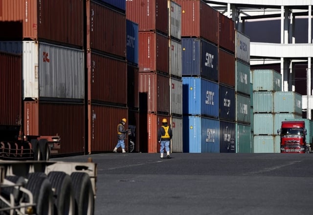 Workers walk in a container area at a port in Tokyo, Japan January 25, 2016. REUTERS/Toru Hanai/File Photo