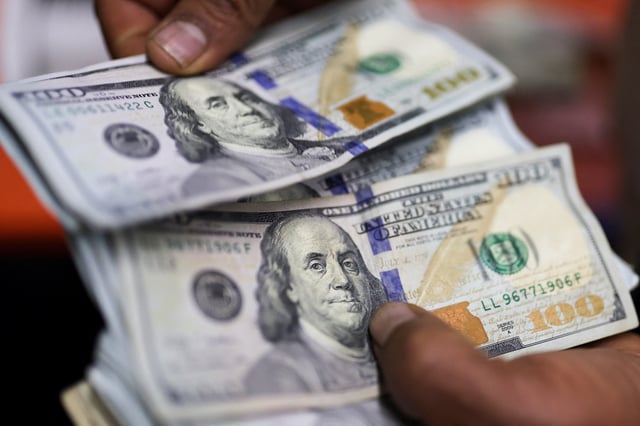 An employee counts U.S. dollars in an exchange house, in Bogota, Colombia January 27, 2025. REUTERS/Luisa Gonzalez/File Photo