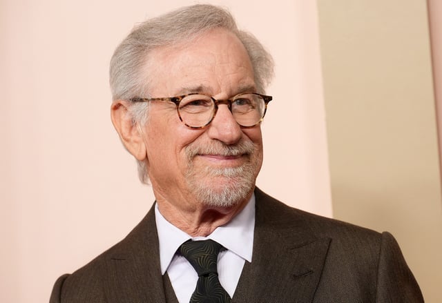 Steven Spielberg wearing a suit and tie smiling