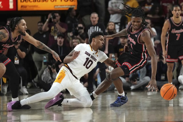 Arizona State guard BJ Freeman and Houston forward Joseph Tugler (11) fight for a loose ball during the first half of an NCAA college basketball game, Tuesday, Feb. 18, 2025, in Tempe, Ariz. (AP Photo/Rick Scuteri)
