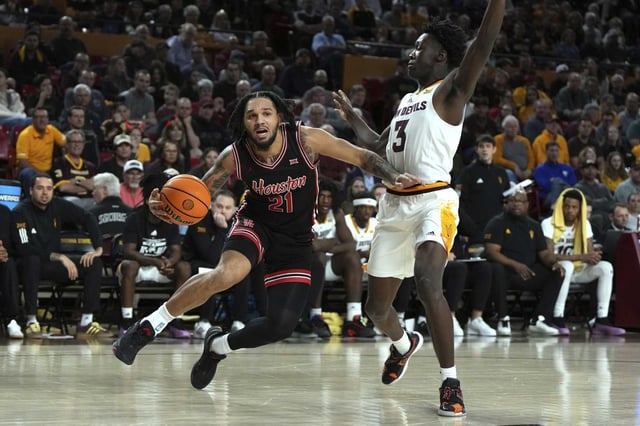 Houston guard Emanuel Sharp (21) drives on Arizona State guard Joson Sanon during the first half of an NCAA college basketball game, Tuesday, Feb. 18, 2025, in Tempe, Ariz. (AP Photo/Rick Scuteri)